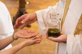 A priest anointing a sick person with holy oil
